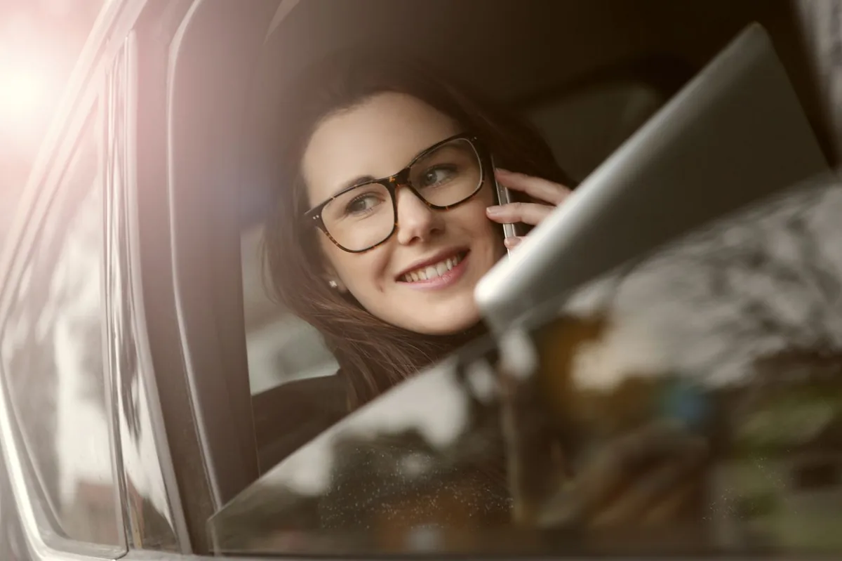 Driver on the phone in a car getting an SR-22 insurance quote